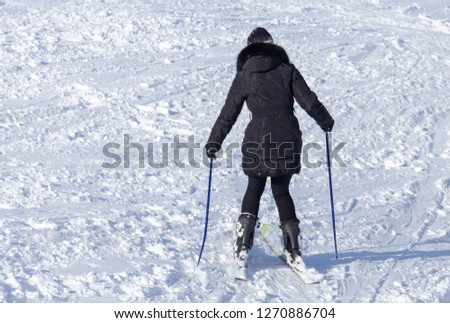 Girl skiing in the snow from the mountain .