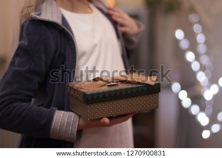 Children's hands hold gift box