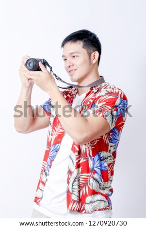 A Portrait of young tourist asian man wearing floral shirt and showing gesture sign
 or laptop, Smartphone, camera  and wallet stand in isolated background
