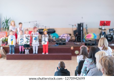 Children's holiday in kindergarten. Children on stage perform in front of parents. image of blur kid 's show on stage at school , for background usage. Blurry.