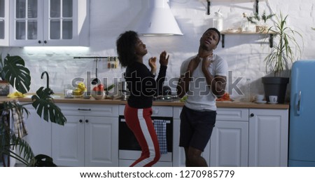 Medium shot of a happy couple dancing in the kitchen