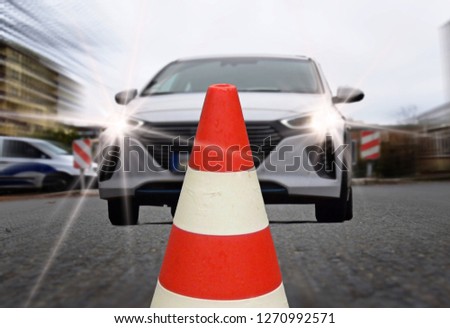 White car makes brakes in front of a pylon