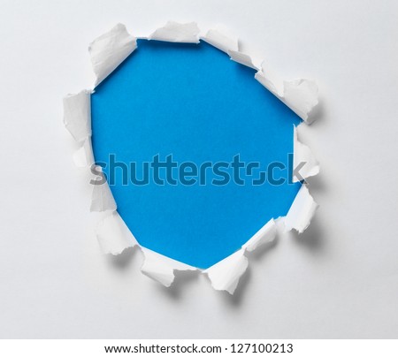 torn hole on the paper with blue background