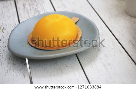Yellow cake on the white wood background.
