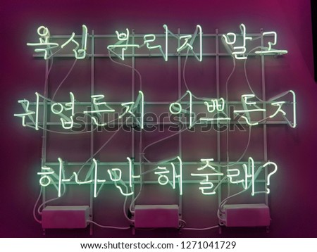 A neon sign for a cafe or pub in Korean.
It means "Don't be greedy. Choose between cute and pretty."