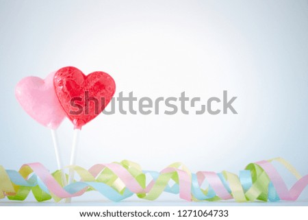 Two heart candy lollipops with ribbons for Valentine's Day. Slight vignette.