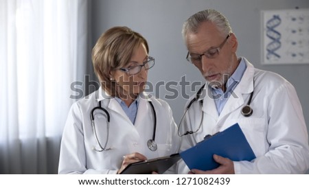 Colleagues comparing results, male and female doctors consulting on diagnosis Royalty-Free Stock Photo #1271082439