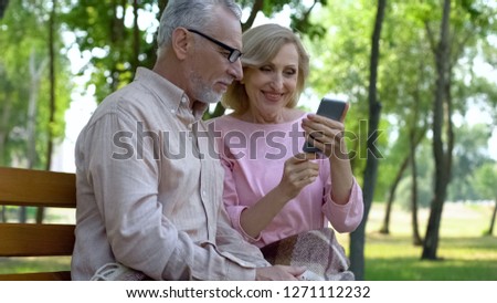 Elderly couple watching video in smartphone, online connection, internet call