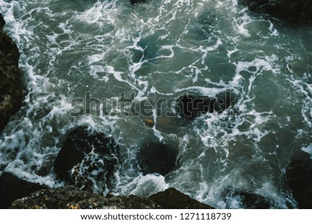 Top view of small waves hitting and splashes against the sea shore at Phuket beach in Thailand. Waves hitting rock.