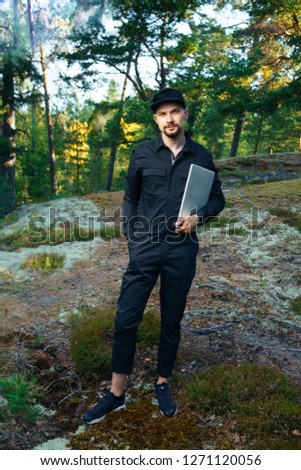 portrait of young traveler rock climber on the background of spellbinding landscape of Norwegian  in which it is impossible not to fall in love work on laptop