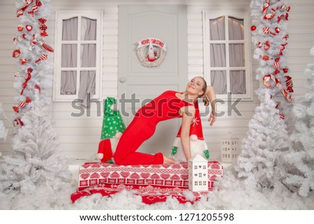 charming girl in a retro gymnastic suit plays sports and poses against the background of her winter white holiday home
