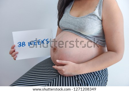 Pregnant woman showing her number of weeks pregnancy