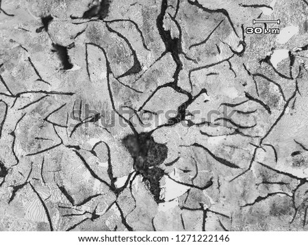 Micrograph of cracked gray cast iron shows by long continuos darkest  line at the middle. The microstructure is pearlitic gray cast iron with graphite flakes in pearlite and alfa ferrite matrix. Royalty-Free Stock Photo #1271222146