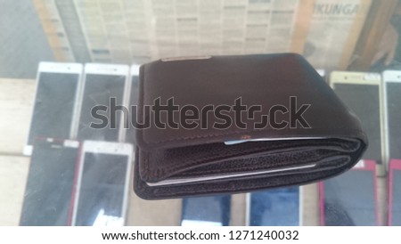 brown leather wallet above the glass counter.