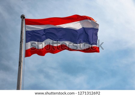 The flag of Thailand on the pole with the blue sky