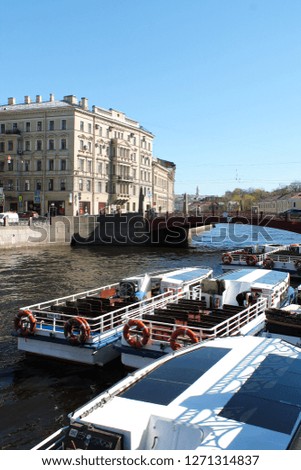Spring landscape with river ships on the water, city street and bridge