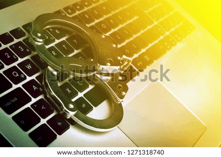 Cyber Crime, computer keyboard and handcuffs