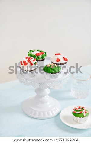 Homemade Christmas cupcake with traditional red green decorative symbols elements