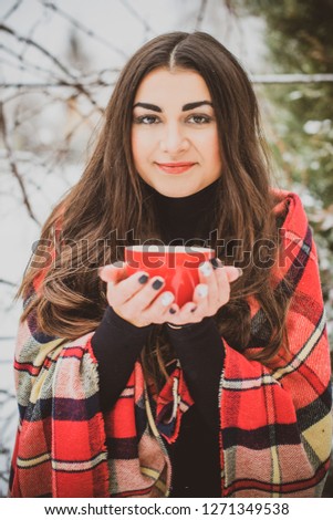 Relaxed arabic woman in plaid and cup of coffee at winter morning at home yard 