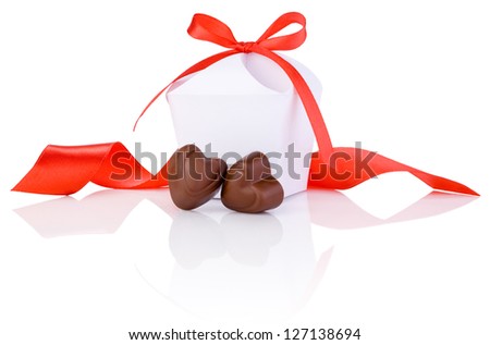 Two chocolate candies in heart shape, white box and red ribbon Isolated on white background