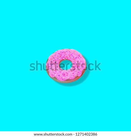 Creative art made with one pink doughnut on blue background.
