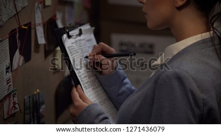 Criminal investigator drawing up record, writing down case details, inquiry