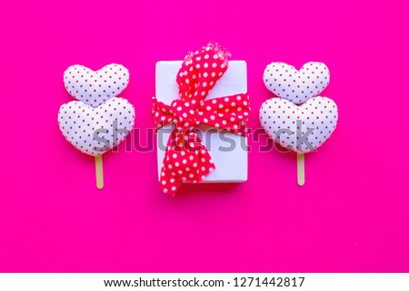 Gift box with Valentine's hearts on pink background. Top view