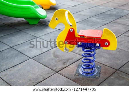 Colorful Rocking Spring Horse in the Outdoor Children Playground.