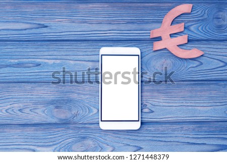 smartphone, the Euro sign on a wooden background. Internet. business, Finance, currency.