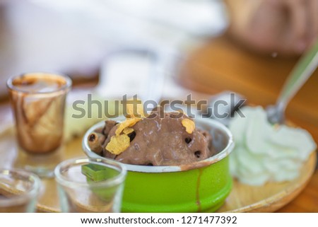 The background of the chocolate ice cream, decorated with colorful cups, modern and traditional design together, is a menu for customers to choose and take pictures before eating.