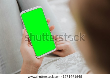 Mockup chroma key image of woman's hands Green screen smartphone. holding mobile phone. close up.