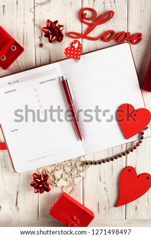 Flatlay for for Valentine's Day. White boards with red hearts, text love, gifts and treasure.