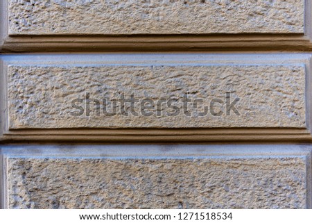 Close-up photo. Fragment of masonry wall with decorative plaster.