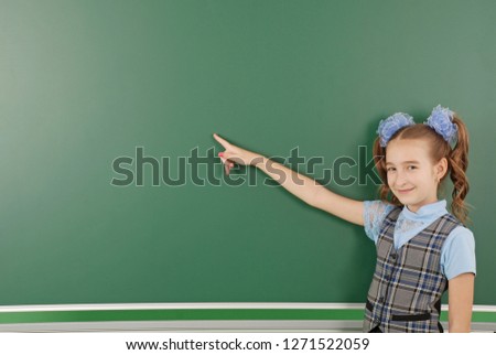 Cute girl schoolgirl near blackboard the concept of education and school life