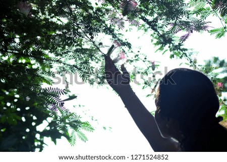 Photo of a girl trying to grab a flower