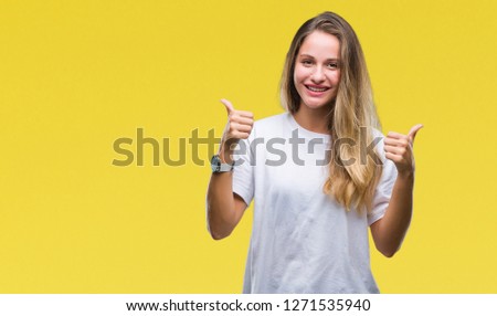 Young beautiful blonde woman wearing casual white t-shirt over isolated background success sign doing positive gesture with hand, thumbs up smiling and happy. Looking at the camera