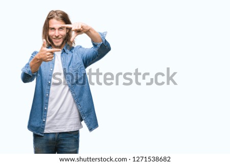 Young handsome man with long hair over isolated background smiling making frame with hands and fingers with happy face. Creativity and photography concept.
