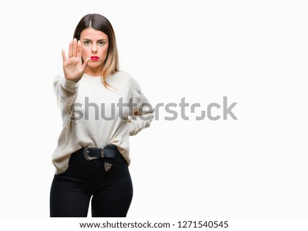 Young beautiful woman casual white sweater over isolated background doing stop sing with palm of the hand. Warning expression with negative and serious gesture on the face.