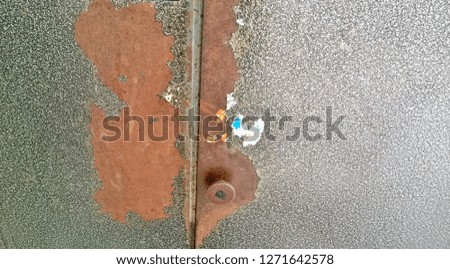 Texture, background, wallpaper of an old brown or black metal wall, door or gate with lock and handle. The door to the public or residential entrance of the house or premises. 