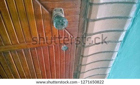 Texture, background, wallpaper of an old brown wooden wall, door or gate with a lock and handle. The door to the public or residential entrance to the house or premises.