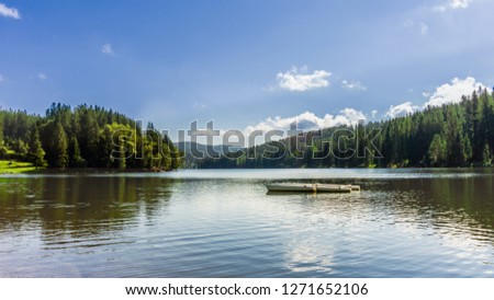 Scenic picture of a boat on a lake surrounded by trees 