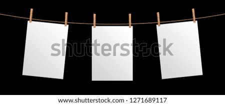 Empty paper sheet hanging on rope, isolated on black background, mock up for your project presentation, poster template
