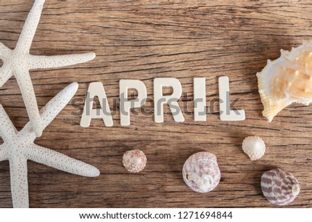 Word "April" made of wooden letters on old wooden background. Timetable concept.