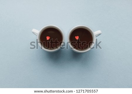 Two cups of coffee with sugar hearts. Love concept. Valentine, marriage morning tea coffee. Blue pastel background. Vintage style