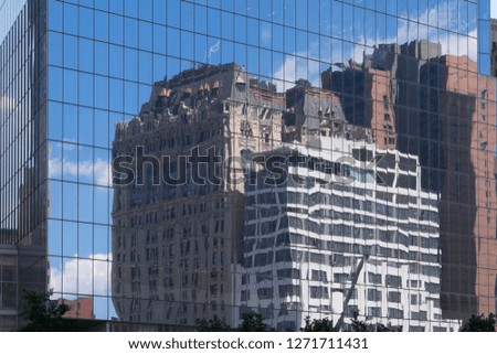 Buildings and sky reflected in the glass windows of a skyscraper in New York, USA