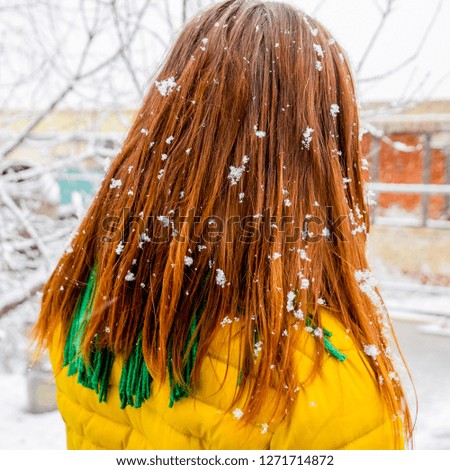 The girl's head in snowflakes. Snowflakes on girl's hair.