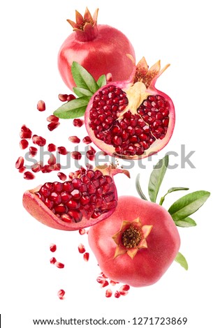 Flying in air fresh ripe whole and cut pomegranate with seeds and leaves isolated on white background. High resolution image Royalty-Free Stock Photo #1271723869