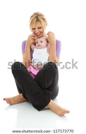young beautiful caucasian mother holding her baby daughter doing baby yoga