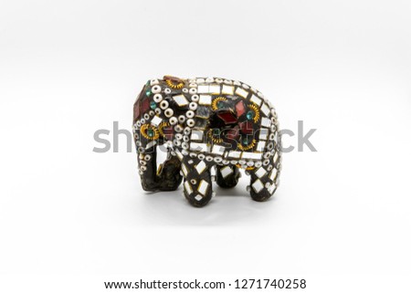 Macro shot of an elephant statue with bead and golden eyelids. Covered with mirrors