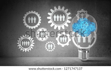 Lightbulb with cloud from gears inside placed against social gear structure on grey wall. 3D rendering.